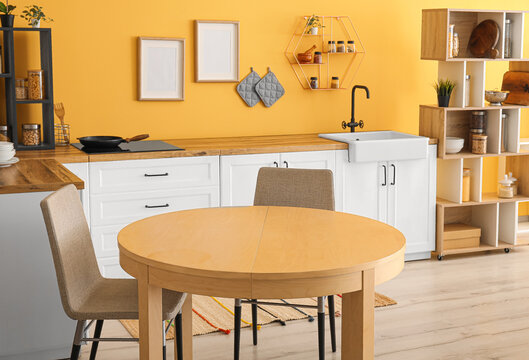 Interior of stylish kitchen with table and white counters