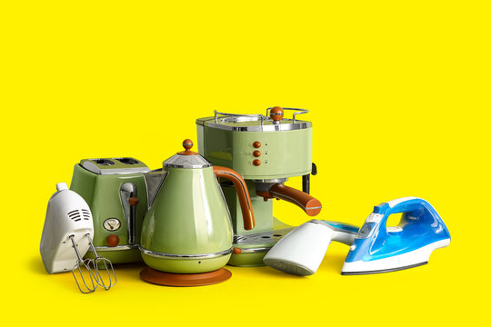 Set of modern household appliances on yellow background