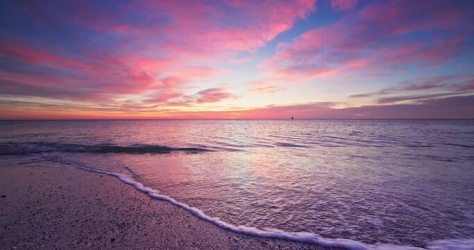 Beautiful ocean sunrise above the ripple water and beach shore, tropical morning on a island