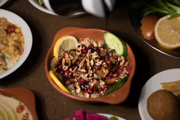 Roasted eggplant ('baba ganoush') topped with walnuts, lemon slices, and cucumber slices, served Syrian style..