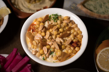 Chickpeas and yogurt are cooked together to make a tasty dish, topped with fried pita bread and sliced almonds.