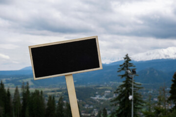 Empty blackboard label with copy space on background of Snowy mountains, green forests In National park Zakopane Poland. Mountain nature landscape. Travel outdoors green tourism concept Naturecore