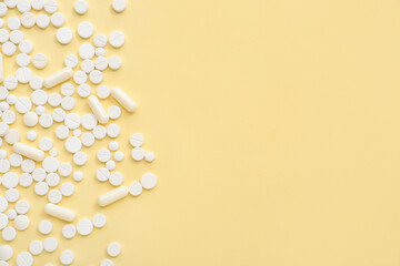 White pills on yellow background