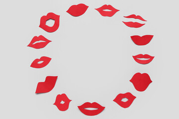Frame made of red paper lips on light background