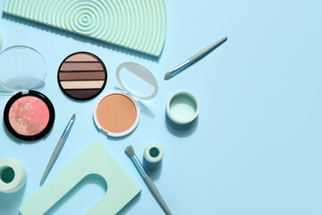 Decorative cosmetics with brushes and podiums on blue background