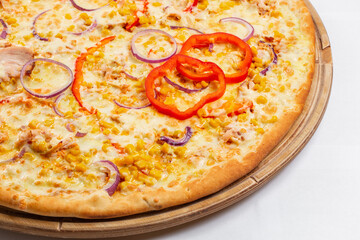 Pizza with chicken, paprika and corn. Italian kitchen and cooking concept. Chief with a pizza cutter cutting pizza to pieces at Neapolitan pizzeria.