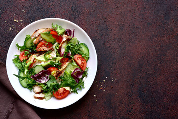 Fresh salad leaves with vegetables and grilled chicken fillet. Top view with copy space.