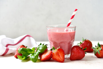 Fresh banana strawberry smoothie with basil in a glass.