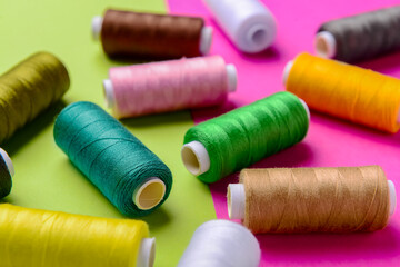 Composition with different thread spools on color background, closeup