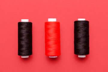Set of thread spools on red background