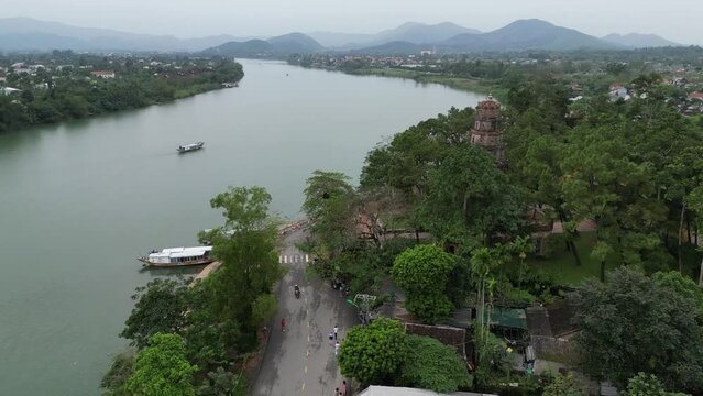 Drone footage at Thien Mu Pagoda near Hue along the perfume river, a must to see in Vietnam. Surrounded by mountains and green vegetation camera is moving foward the pagoda 1-2