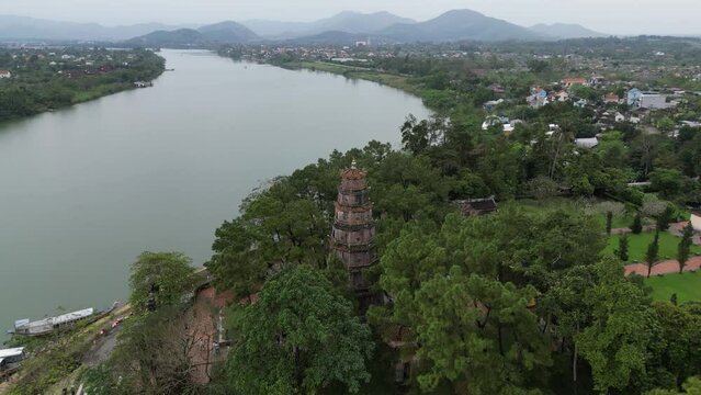 Drone footage at Thien Mu Pagoda near Hue along the perfume river, a must to see in Vietnam. Surrounded by mountains and green vegetation camera is moving foward the pagoda 2-2