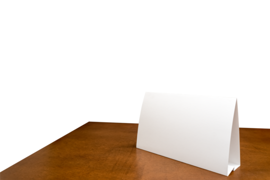 Blank paper table card on wooden table over white isolated background. Picture text can be inserted for advertising communication.