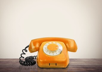 A retro colored old telephone on a table.