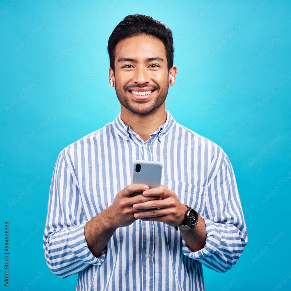Aufkleber Happy, portrait and a man with a phone for communication isolated on a blue background in a studio. Smile, social media update and a person typing on a mobile for app, notification reply and message