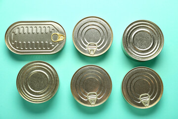Assortment of tin cans with fish on turquoise background