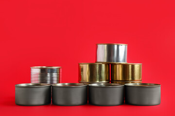 Assortment of tin cans with fish on red background