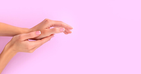 female hands with french manicure on pink background