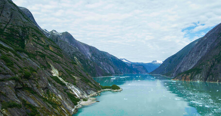 Fototapeta na wymiar Rocks, melting ice, glaciers, rivers, forests and mountains seen from above. Stunning aerial views of Alaska in summer from a drone.