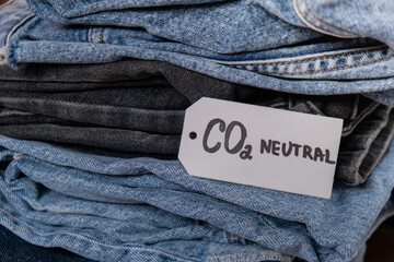 CO2 neutral emission text note on stack of jeans. Ecology nature friendly, climate change, green...