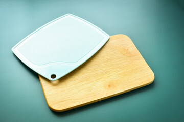 blue and brown wooden cutting board on green background, equipment for cooking in the kitchen