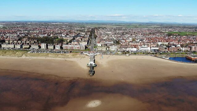 Reverse aerial shot of Lytham St Anne's pier and old boat jetty on a sunny day