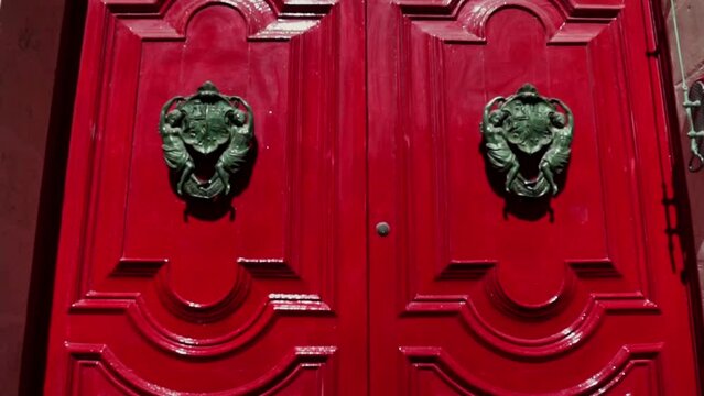 Reveal of red doors with a huge door knobs of an old building