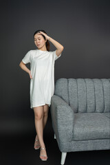 Obraz premium Asian woman posing elegantly on a sofa for portrait photography