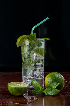Mojito cocktail in tall glass against black background