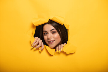 portrait of woman tearing yellow background