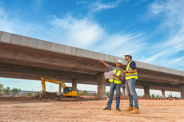 Asian architect and mature supervisors meeting at construction site Multiethnic workers and...