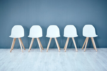 Human resources, hiring and recruitment with a row of chairs in a studio on a gray background...