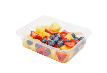 Fruit salad with pineapple, strawberries and blueberries in a plastic container on a white background.