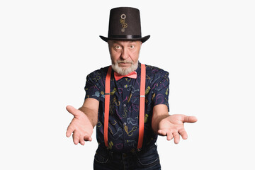 Old man in a festive costume in a cylinder hat with a pink bow tie and suspenders invites you to a holiday. Concept - tricks