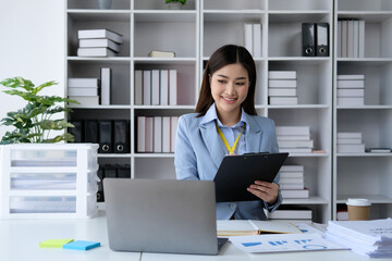 Young woman working on documents and laptop