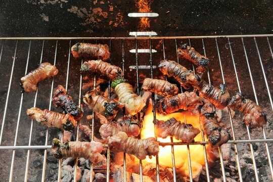 ITALY CANOSA DI PUGLIA APRIL 20 2023 APULIAN TORCINELLI COOKED ON THE GRILL.THEY ARE SMALL ROLLS OF LAMB ENTRAILS