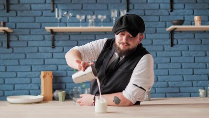 Classic berded barista prepares an alcoholic cocktail. Sweet creaminess of whipped cream and coconut, light acidity of pineapple juice, refreshing ice, and exotic notes of rum. Hot vibrant summer.