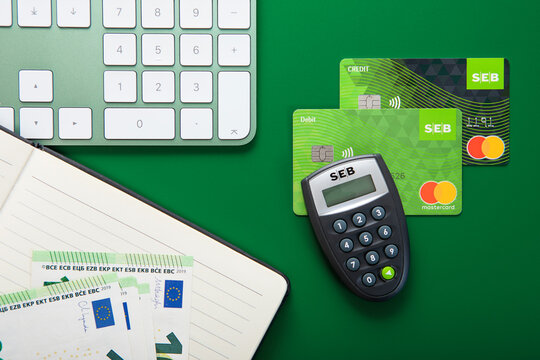 LONDON,UK - NOVEMBER 15, 2022: Seb bank credit and debit mastercard on green with code calculator and euro banknotes.