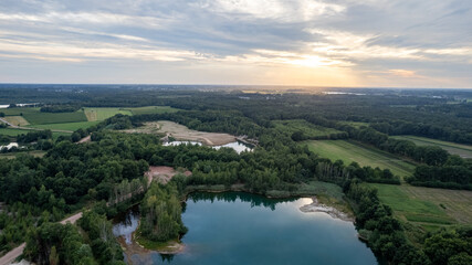 Fototapeta na wymiar Aerial view panorama of green summer forest, corn fields and blue lake. Rural landscape. Drone photography from above. High quality photo