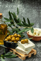 Feta Greek cheese with olives and olive oil on light background. vertical image. top view. place for text