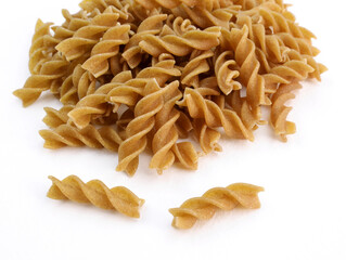 Heap of raw dry eggless rye fusilli. Organic wholemeal rye spiral pasta. Brown durum macaroni on a...