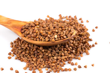 Uncooked buckwheat on wooden spoon