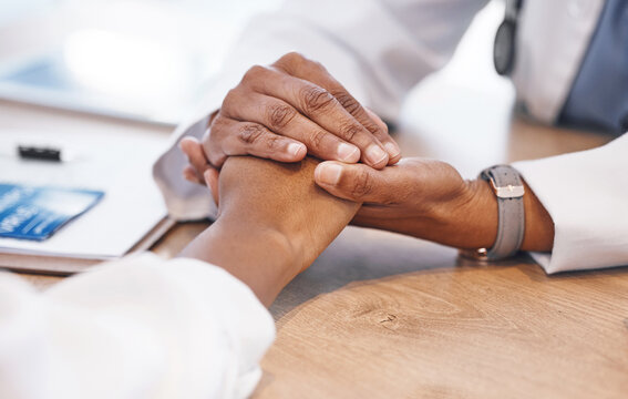 Closeup, holding hands and doctor with support for patient with consulting, listening and empathy at desk. Medic, woman and helping hand for solidarity, care and counselling for health with bad news