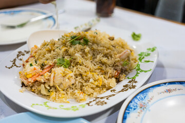 Thai fried rice with prawns and egg on the white dish. Close up