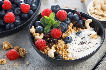 Dry granola with blueberries and raspberries with chia seeds yogurt. Healthy breakfast meal