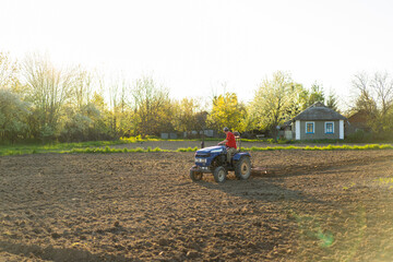 The tractor drives across the field and cultivates the land. Agricultural vehicle works in...