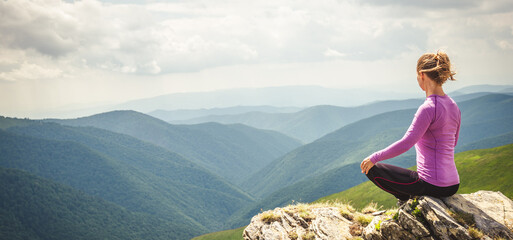 Young woman on the top of mountain