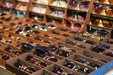 market stall filled with a diverse selection of sunglasses, showcasing affordable eyewear options...