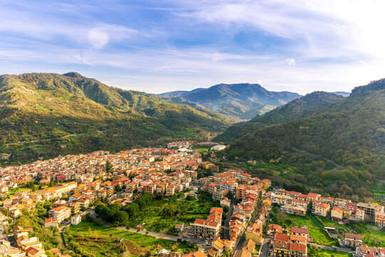 amazing mountain travel landscape of view on highland valley town with mountains and beautiful cloudy sunset on background