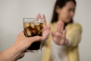 Dieting or good health concept. Young woman rejecting Junk food or unhealthy food such as sweet soda drink and choosing healthy food such as fresh fruit or vegetable.